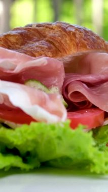 Jamonlu jambonlu kruvasan sandviçi ve domatesli marul sebzeler, Fransa 'da kahvaltıda sağlıklı, pahalı ve zengin peynirleri beyaz tabakta bırakır. pahalı restoran