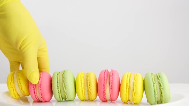 カラフルなフランスのデザート ピンクのバックグラウンドでケーキマカロンやマカロン カラフルなアーモンドクッキー パステルカラー 甘いブレイクモックのためのマカロン フラットレイ — ストック動画