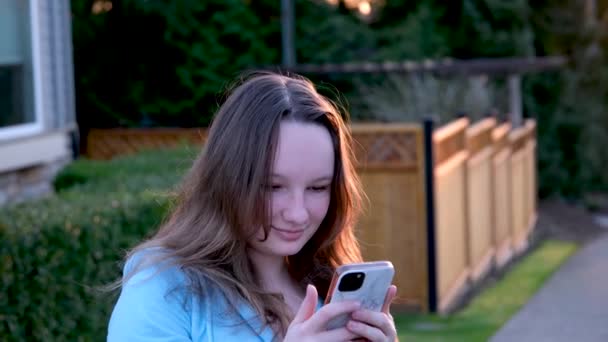 屋外で携帯電話でテキストを送る かわいいコーカサス女の子 高品質の写真 — ストック動画