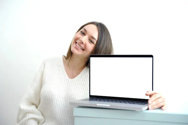 ノートパソコンの画面を指し ノートパソコンの画面を指す20代の女性の原因の肖像画 ウェブサイトのための空の空白の画面のモックアップと現代のラップトップを保持女性 笑顔の幸せな女の子 隔離された白い背景 ロイヤリティフリーのストック画像