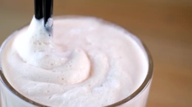 Sütlü şekerli frappe. Lokantada bir kamışla karıştırılmış kremalı buzlu kahve. Buzlu soğuk kahve içeceğim. Sabah erken güneş ışığı. 