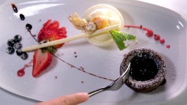 Çatalla browni yemek. Çikolatalı pastadan çikolata kremalı ve ahududulu bir ısırık almak. Yüksek kalite 4k görüntü