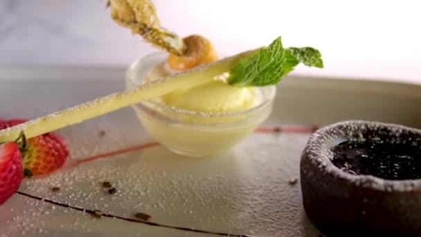 ホットチョコレートとミントの物理バニラアイスクリームとホワイトプレートの美味しい新鮮な好み クローズアップ — ストック動画