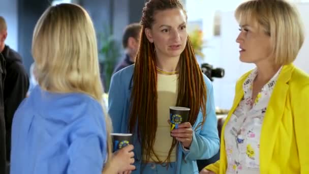 Три Женщины Корпоративной Вечеринке Одетые Синий Желтый Пластиковой Бумажной Чашкой — стоковое видео