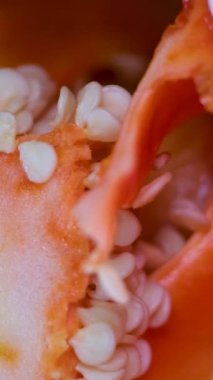 Profesyonel aşçı eldiven giyer, kırmızı dolmalık biber keser. Kahverengi ahşap tahtaya su damlatır. Restoranda çok yakın plan çekilir. Yüksek kalite 4k görüntü