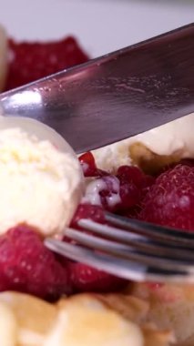 Elektrikli waffle ızgara ızgarasında tatlı waffle hazırlarken çekilen dikey video işlemi yumurta malzemesi şekeri yakın çekim yemek tarifi ekler. Kahvaltıda ahududu yemek ve video dekorasyonu.
