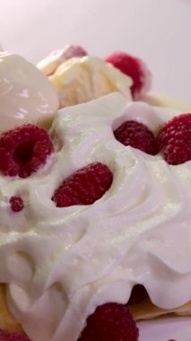 Elektrikli waffle ızgara ızgarasında tatlı waffle hazırlarken çekilen dikey video işlemi yumurta malzemesi şekeri yakın çekim yemek tarifi ekler. Kahvaltıda ahududu yemek ve video dekorasyonu.