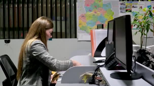 フォルダ ドキュメンテーション 灰色のジャケットの女性は さまざまな文書をレビューし 折り紙のシートをフォルダに折り畳み ファイルやコンピュータにページを飛ばします — ストック動画