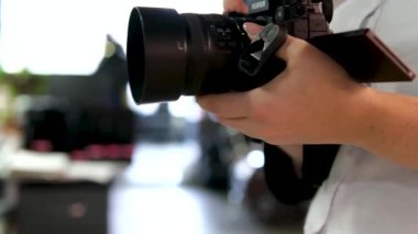 Fujifilm kameralı orta yaşlı kadın fotoğrafçı ofiste gülümseyerek fotoğraf çekmekle meşgul. Beyaz ceketli sarışın Ukrayna Vinnitsa 10.2023