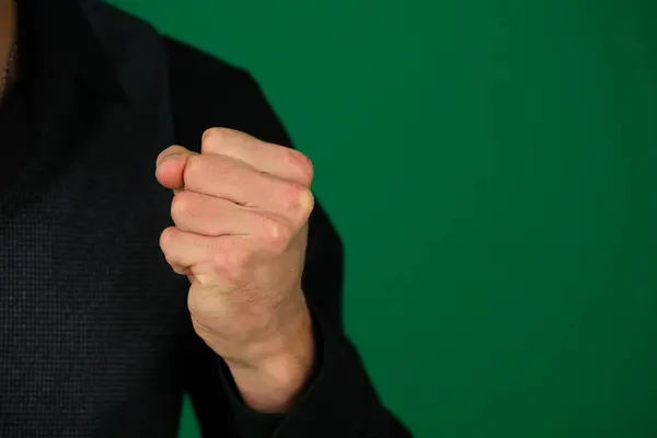 Yeşil arka plandaki yakışıklı bir adamın duyguları. Koyu renk, yakın plan, genç adam. Vücut kısmı için fotoğraf.