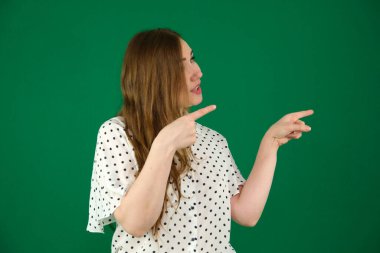 Genç, şişman, güzel bir kadının stüdyo çekimi. Güzel bir kadın gülümsüyor, gülümsüyor ve beyaz arka planda izole edilmiş bir parmakla yüzünü işaret ediyor. Yüksek kalite fotoğraf