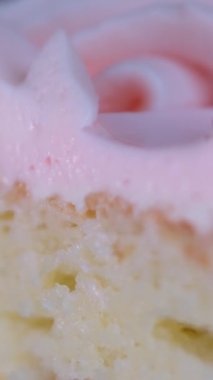 Beyaz bir tabakta dönen pembe çilekli pastayı kapat. Çatalla cheesecake yemek. Cheesecake 'ten bir ısırık alıyorum. Tatlı tatlı yemek.