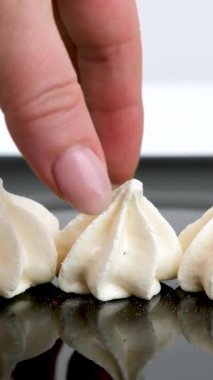 Pasta hazırlayan bir kadın kremalı pastayı mahvediyor. Kremayla kaplanmış kremalar bir tabağa istiflenir. Yakın plan. Yüksek kalite 4k görüntü