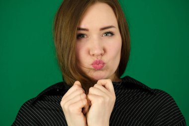 Siyah çizgili erkek tişörtlü yeşil arka plan kromatonlu bir kadın farklı yüz ifadeleri mesaj temizleme için yakın çekim reklam alanı. Güzel gözler güzel kız öpücükler saçıyor. Yüksek kalite