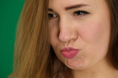 Yaşam tarzı, duygu ve vücut dili kavramı: kıvırcık saçlı güzel genç kadın yeşil arka planda yalnız poz veriyor. Yüksek kalite fotoğraf