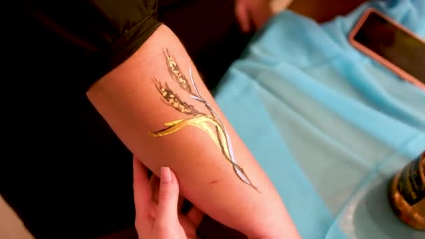 女人手上的身体艺术用黄色和蓝色绘画艺术美容师画麦穗 — 图库视频影像