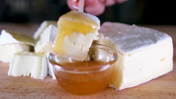 ブリータイプのチーズ カマンバートチーズ 新鮮なブリーチーズとナッツ 葉が付いている木板のスライス イタリア語 フランスチーズ — ストック動画