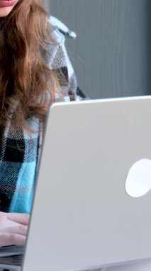 Sundurmada dizüstü bilgisayarla çalışırken gülümseyen güzel, neşeli genç bir kadının görüntüsü. Güzel bir genç kız.