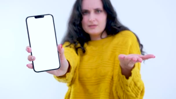 染色体広告のテキストのための白い画面スペースを持つ携帯電話を持つ憤慨と不満の女性は 指の驚きの失望の怒りを示しています イギリス侵略 — ストック動画