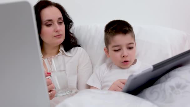 Anne Oğlu Beyaz Battaniyenin Altında Yumuşak Bir Yatakta Erkek Tabletinin — Stok video