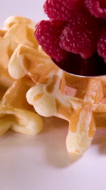 Lezzetli waffle 'ları elektrikli waffle ızgarasında yumurta çırpma malzemesi kullanarak hazırlama işlemi. Yumurta, şekeri yakın plan yemek tarifi olarak ekliyor. Ahududu süsler. Bir dizi video.