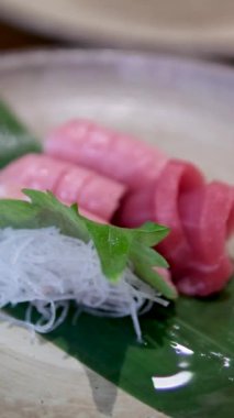 Yenebilir altın süslemelerle süslenmiş sosla kaplanmış pirinç vermicelli ile ton balığı eti, restoranda yemek pişiren bir erkeğin eldiveni için nefis bir hazırlık bırakır. Sushiya.