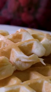 Lezzetli waffle 'ları elektrikli waffle ızgarasında yumurta çırpma malzemesi kullanarak hazırlama işlemi. Yumurta, şekeri yakın plan yemek tarifi olarak ekliyor. Ahududu süsler. Bir dizi video.