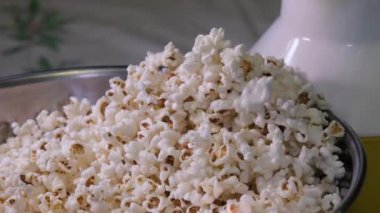 Tuzlu ve tatlı bir lezzet. Demir kasede bir kaşıkla patlamış mısırı karıştırmak akşam filmi için patlamış mısır hazırlamak.