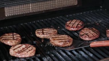 Izgarada, mangal kömürü ve taze köftelerle barbekü için ev yapımı burger arkaplanı oluşturan yarım kızarmış köfteler var. Mangalda ateşte pişen hamburgerler.