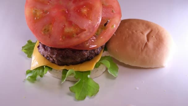 Twee Schijfjes Rijpe Rode Tomaten Een Zelfgemaakte Cheeseburger Sappige Kotelet — Stockvideo