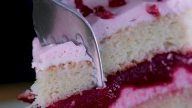 Flamingo pastası ve çilek. Makro ve kaydırak atışı, Halation etkisi restoran masasında yakın plan tatlı, kek ya da dutlu cheesecake. Kız kaşığı elinde tutuyor, kırıyor ve tadıyor.