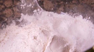Yumurtalı şeffaf bir kasede hamuru hazırlamak için bir çorba kaşığı süt döküyorum. Yüksek kalite 4K görüntü. Yüksek kalite 4k görüntü