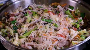 Kızarmış deniz mahsullü cam erişteyi karıştır. Kızartma tavasına soya sosu dök Asya mutfağı vermicelli tavası sebze ve et ile yüksek kaliteli 4k görüntü