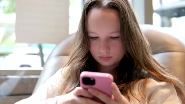 ティーンエイジャーガール スマートフォンを再生 電話でインターネットブラウズ 子供の読書メッセージ デバイス上でオンラインを検索する子供たち 高品質の4K映像 — ストック動画