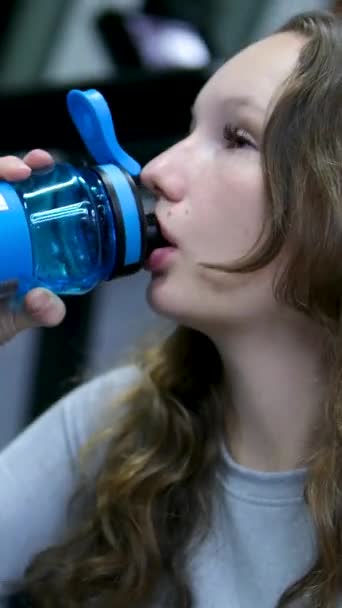 あなたの渇きを癒し プラスチックボトルからきれいな水を飲む ジムの女の子は運動 健康上の利点の間の青い透明なボトルから水を飲む 水をたくさん飲む必要がある — ストック動画