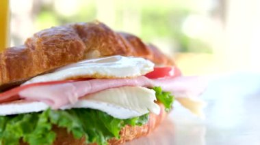 Yakından aşçının elleri eldivenli lezzetli bir kruvasan, peynir, avokado, somon filetosu ve yumurtalı Benedict pişiriyor. Lezzetli ve sağlıklı bir kahvaltı. Yüksek kalite 4k görüntü