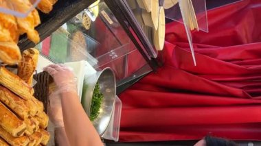 Granville Adası Şekerleme Kadın önlük içinde tepsi üzerinde şeker ayrıştırır ve onları güzel bir şekilde serer pasta ve çörekler için arka planda 2023 Kanada 'da fırından taze taze