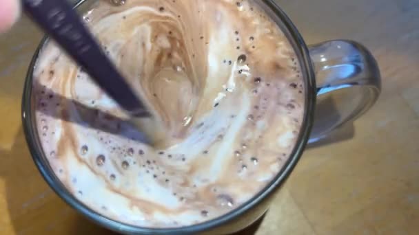 ホットチョコレートミルクの注ぎ マグカップで新鮮に醸造されたコーヒーは 女性の手でスプーンでかき混ぜられます 高品質の4K映像 — ストック動画