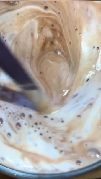 뜨거운 초콜릿 우유는 유리에 숟가락으로 맛있는 뜨거운 라떼의 스쿠핑 두꺼운 — 비디오