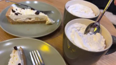 İki elmalı tart ve iki fincan kahve küçük yuvarlak masa üzerinde güzel desenli masa örtüsü.