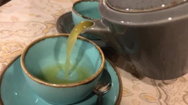 Zencefilli çay, fincanda zencefilli çay ve masada kesilmiş kök. Doğal Vitaminler.