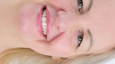 Pamuk süngerci kadının üzerine bodrum suyu dökerek gözüne makyaj çıkarıcı sürerek çerçeveye bakarak gülümsüyor. 