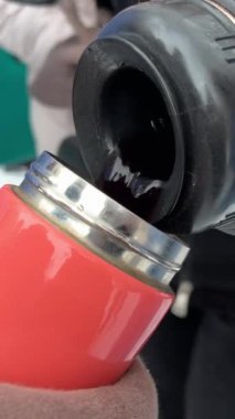 Kışın soğukta sıcak şarap içmek kadınlar lezzetli buhar eldiveni içmek yakın çekim eller şarap çayını termosa doldurmak yürüyüş pikniği. Kışın gezintiye çıkarız