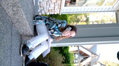 Gençler telefonda dedikodu hikayeleri anlatıyor okulla ilgili haberlerde kız arkadaşlarıyla iletişim kuruyor telefonda konuşan genç kız alet mavisi bluz kullanıyor.