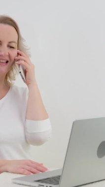 Rahatla, internetten alışveriş, iletişim ve internet için kanepede bir kadınla telefon görüşmesi ve dizüstü bilgisayar. Oturma odasındaki müşterilere teknoloji, iletişim ve danışmanlık