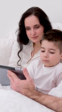 Pankart. En son teknoloji aile eşi ve çocuğu dizüstü bilgisayarda oturup film izlerken birlikte beyaz giysiler giyip sohbet ediyorlar. Anne baba ve oğlu gülerek gülüyorlar.