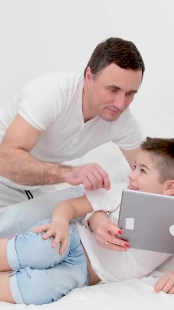 Família Cama Branca Com Tablet Examinando Jogo Pai Mostrando Como — Vídeo de Stock