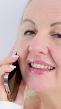 Beyaz bir arka planda güzel bir kadının yüzü telefon şaşkınlığının ellerinde gözlerini aç gözlerini aç gözlerini kapat gözlerini aç ağzını aç tuhaf haberler var