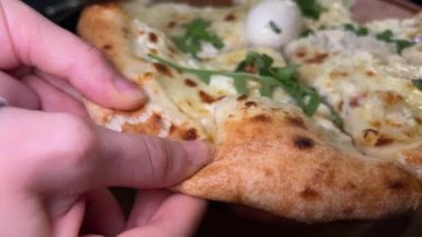 Pizza Margherita quattro formaggi 'nin en yakın görüntüsü. Aşçı pizzayı ekseni etrafında döndürür. Dört peynirli pizza roka ve peynirli mozzarella.