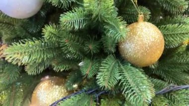 Yakın plan, kusursuz döngülü video: Beyaz arka planda gümüş toplarla süslenmiş yapay Noel ağacı. Noel arkaplanı, süslemeli yeşil köknar dalları. Yüksek kalite 